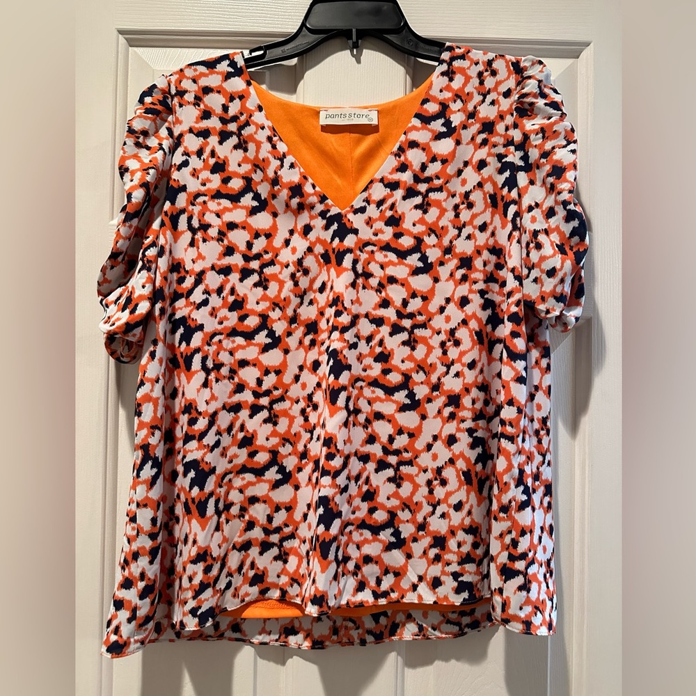 The Pants Store orange and blue top. Size M
Excellent condition